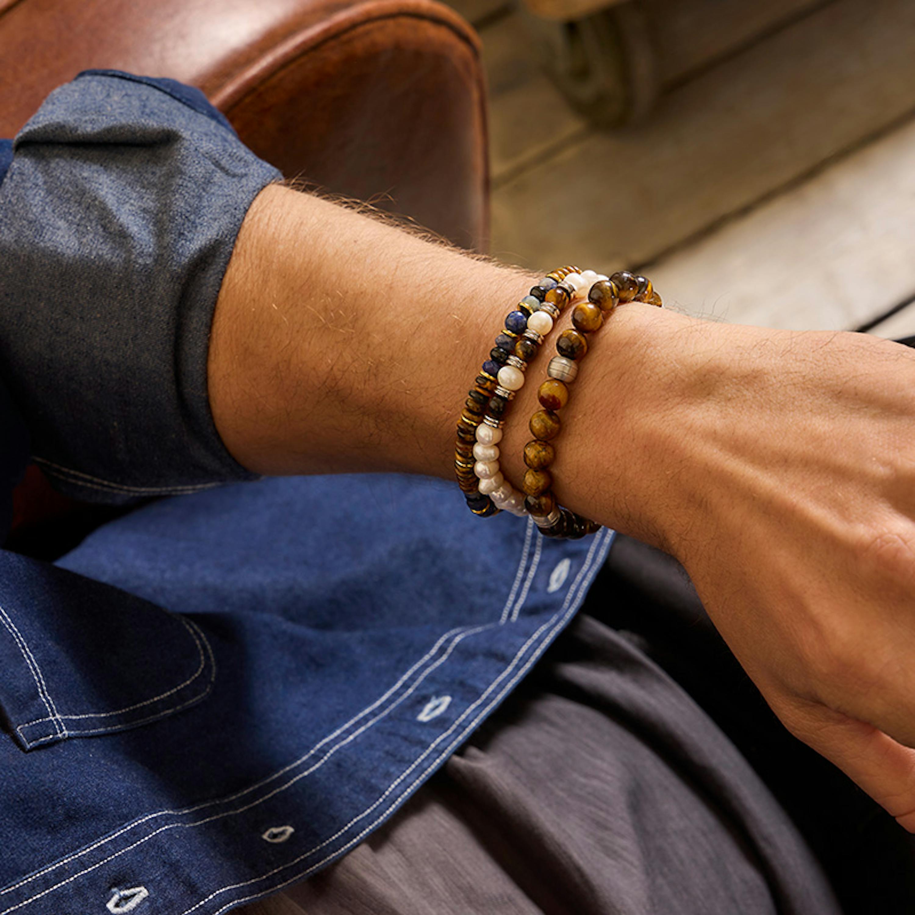 Mann mit verschiedenen Perlenarmbändern der neuen Amor Men Collection