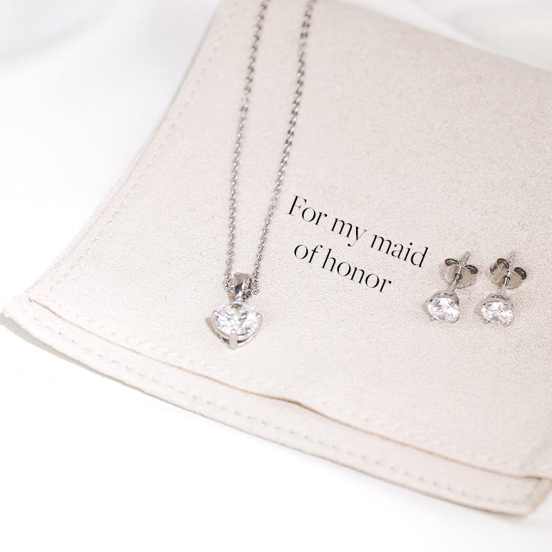 Silberner Schmuck für Damen liegt auf Schmuck Pflegetuch mit dem Schriftzug "For my maid of honor"