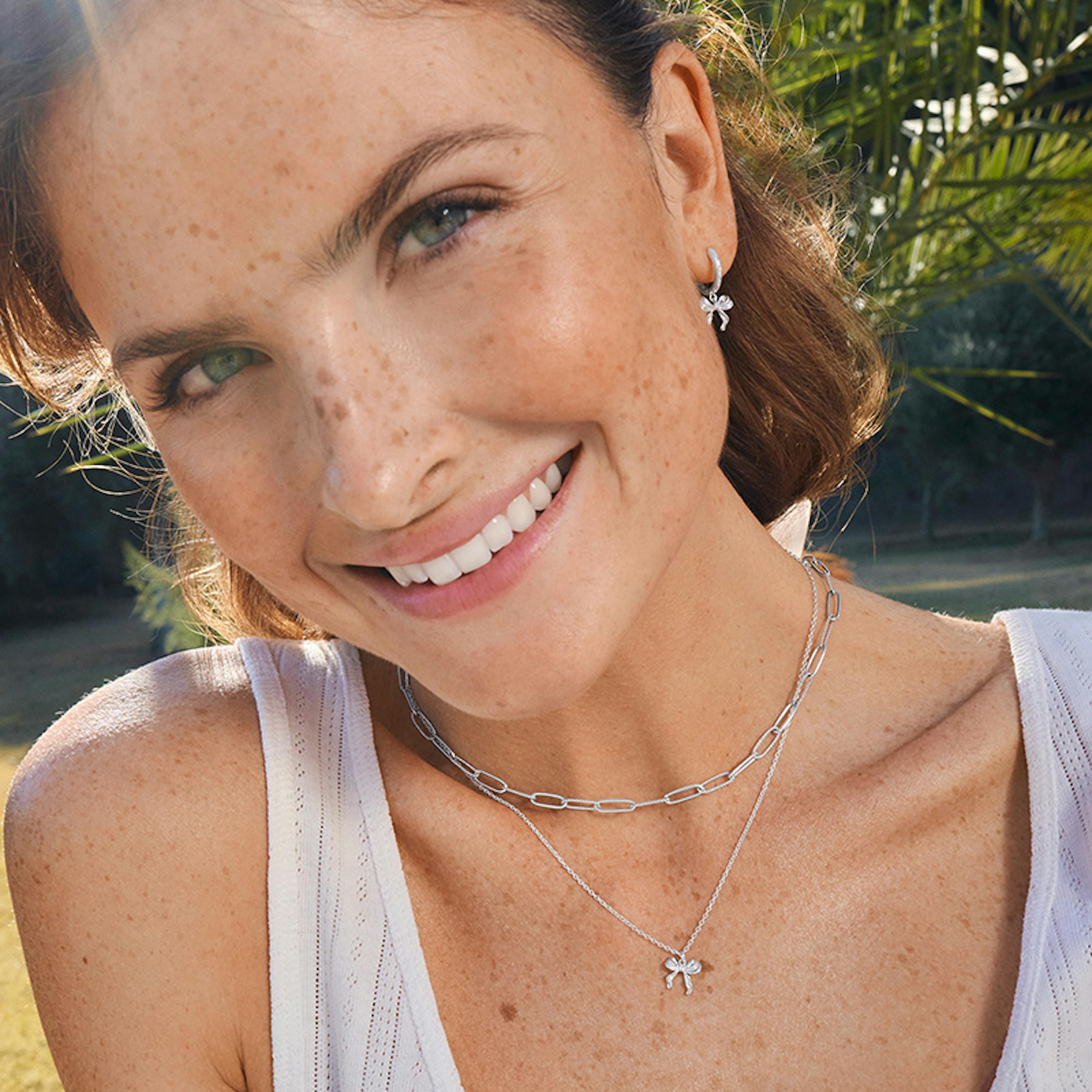 Frau trägt Silberschmuck mit Schleifen Motiv