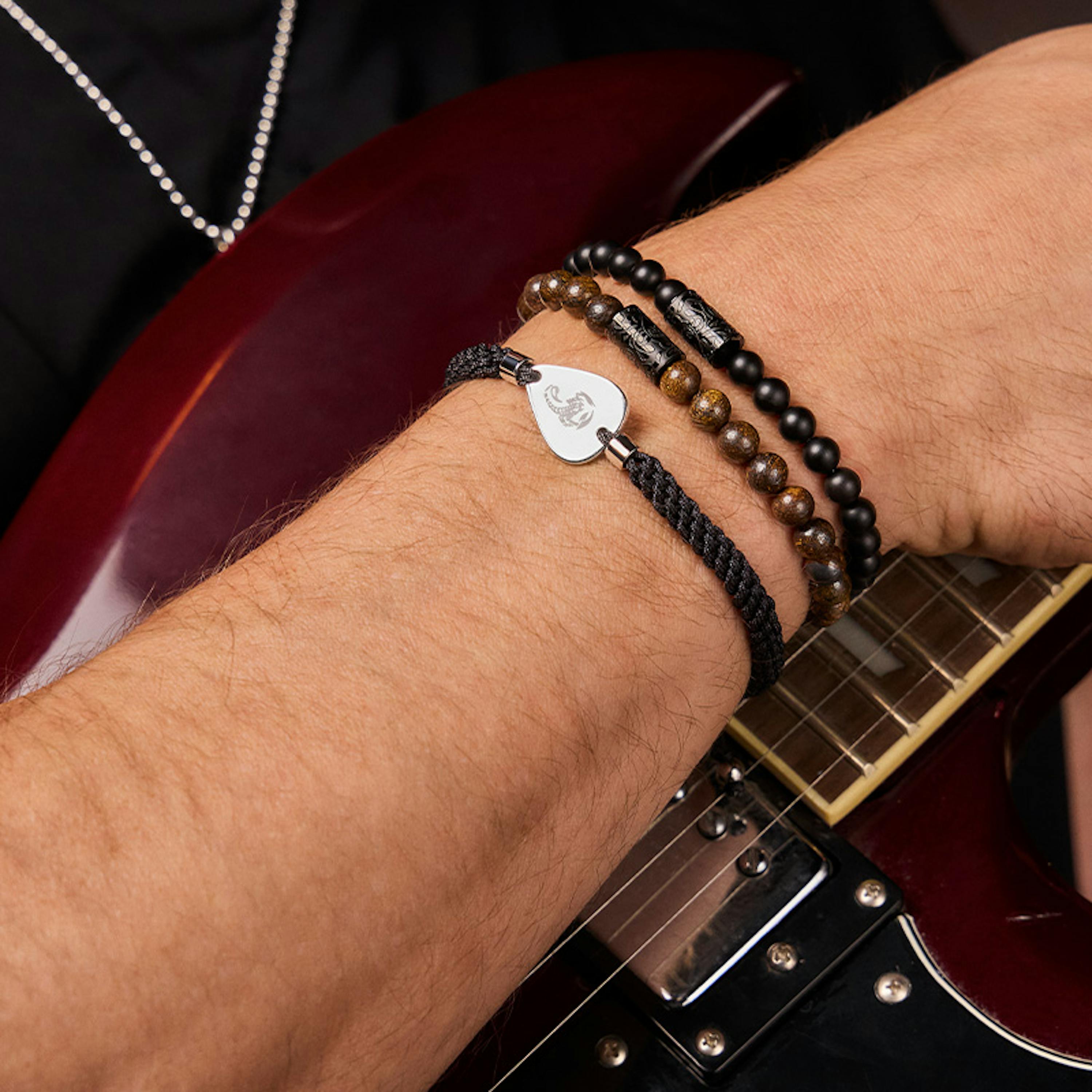 Mann trägt Armbänder der neuen Scorpions Collection und hält E-Gitarre