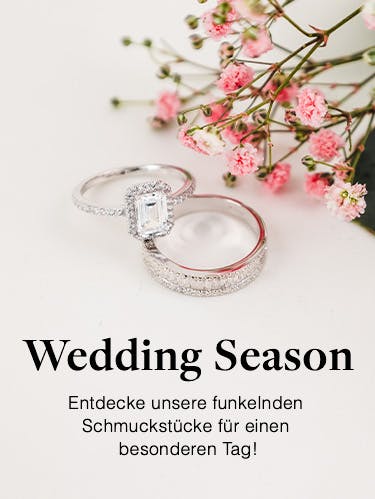 Silberner Verlobungs- und Ehering neben Schleierkraut von Amor