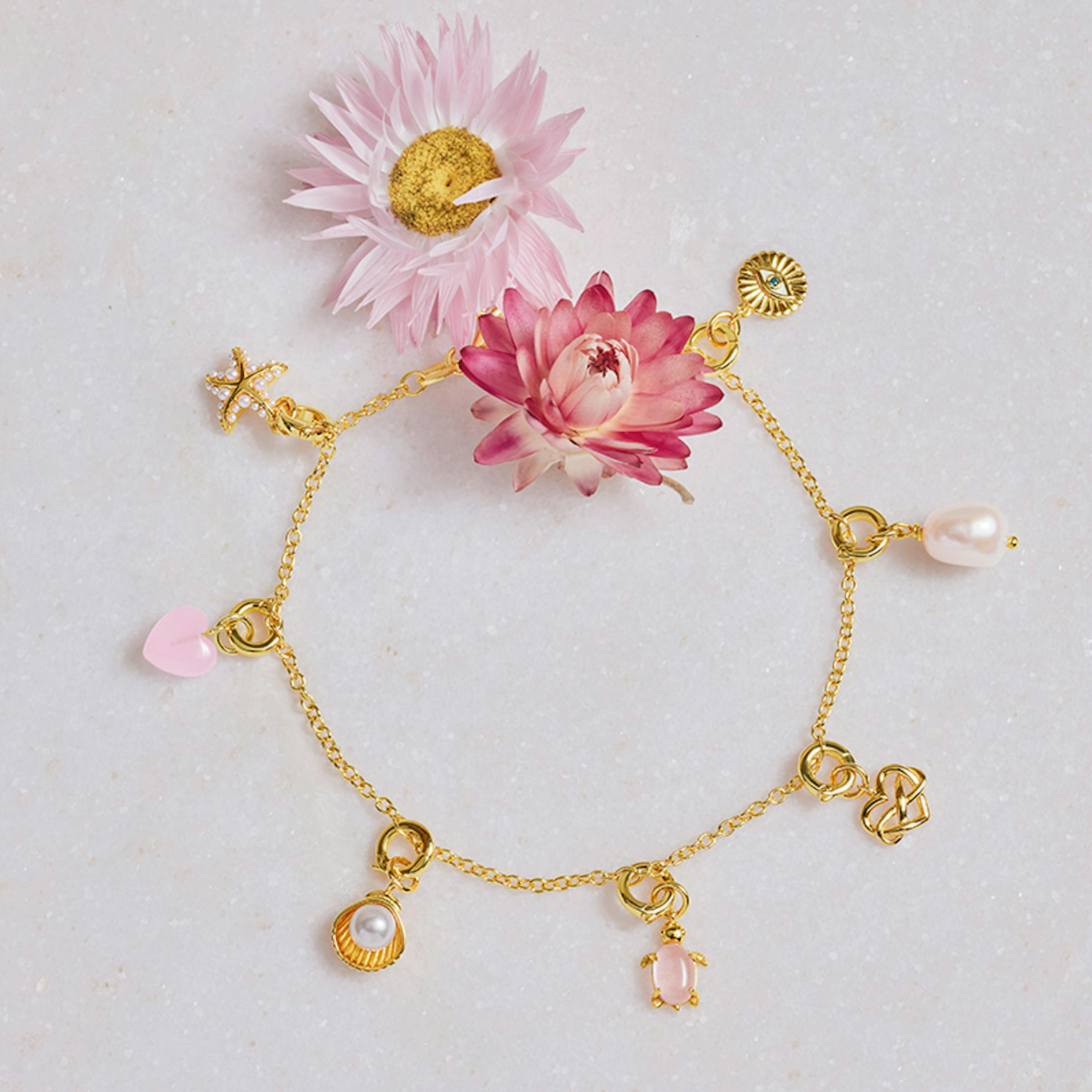 Goldenes Charmarmband mit goldenen Charms und rosa Akzenten