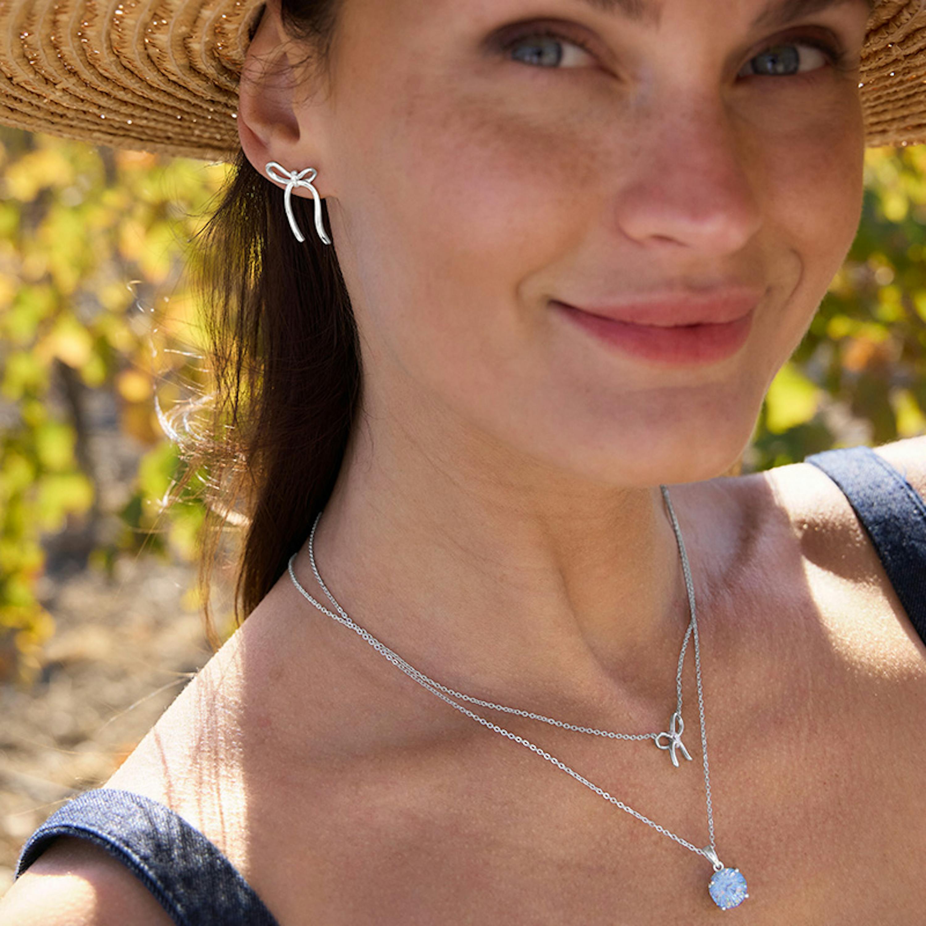 Frau trägt Silberschmuck mit Schleifen Motiv