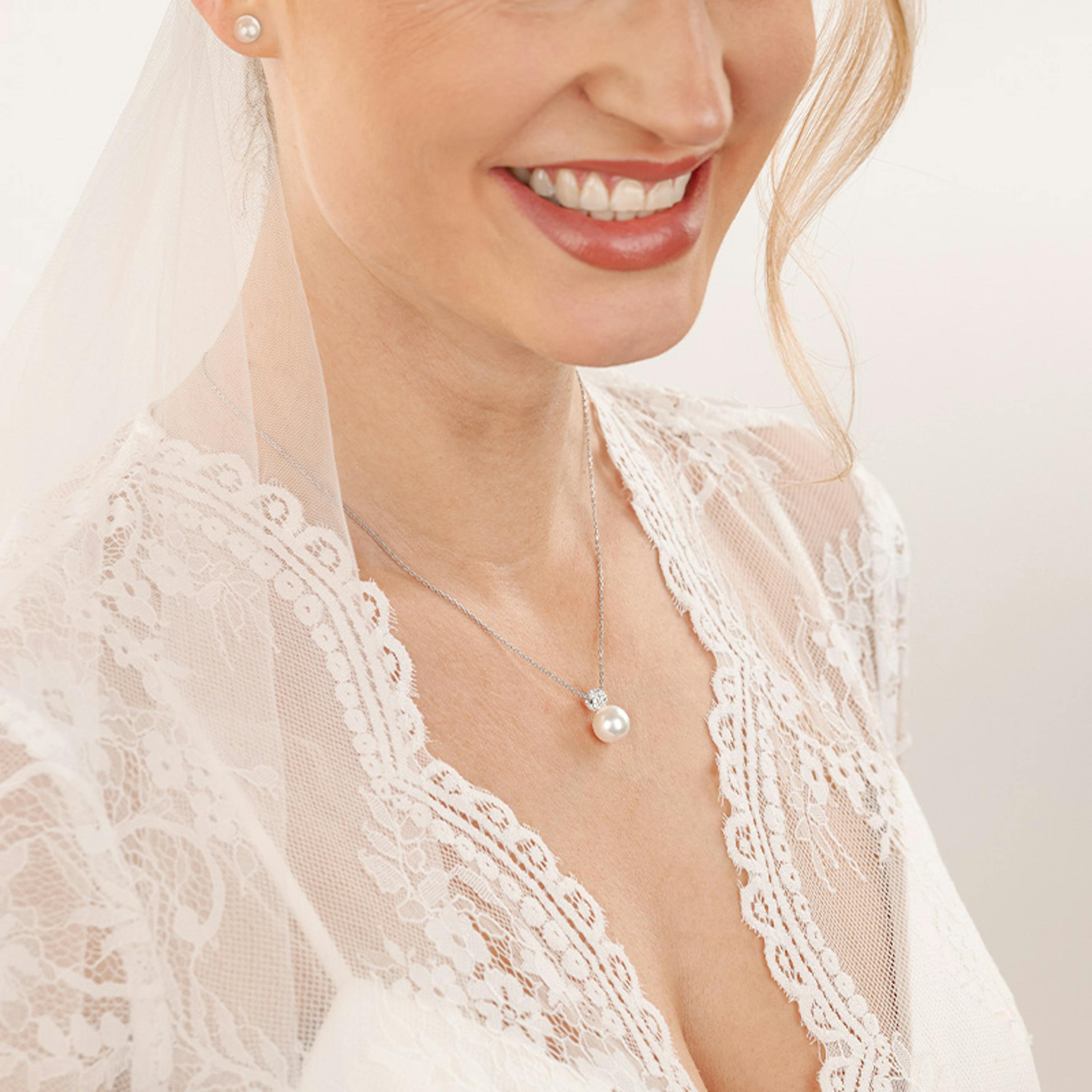 Braut trägt silbernen Perlenschmuck von Amor