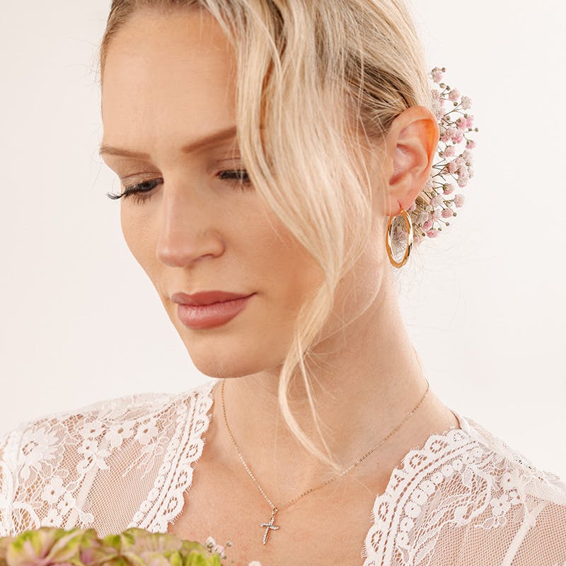 Braut trägt goldene Creolen von Amor zu passender Brautfrisur