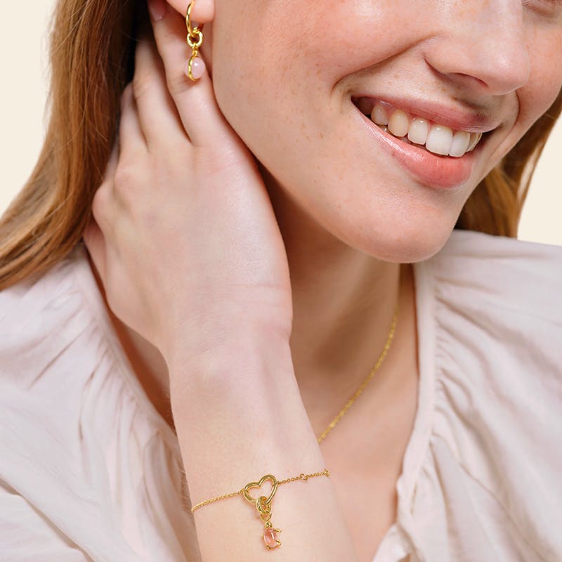 Frau trägt Charmarmband und Charmohrringe