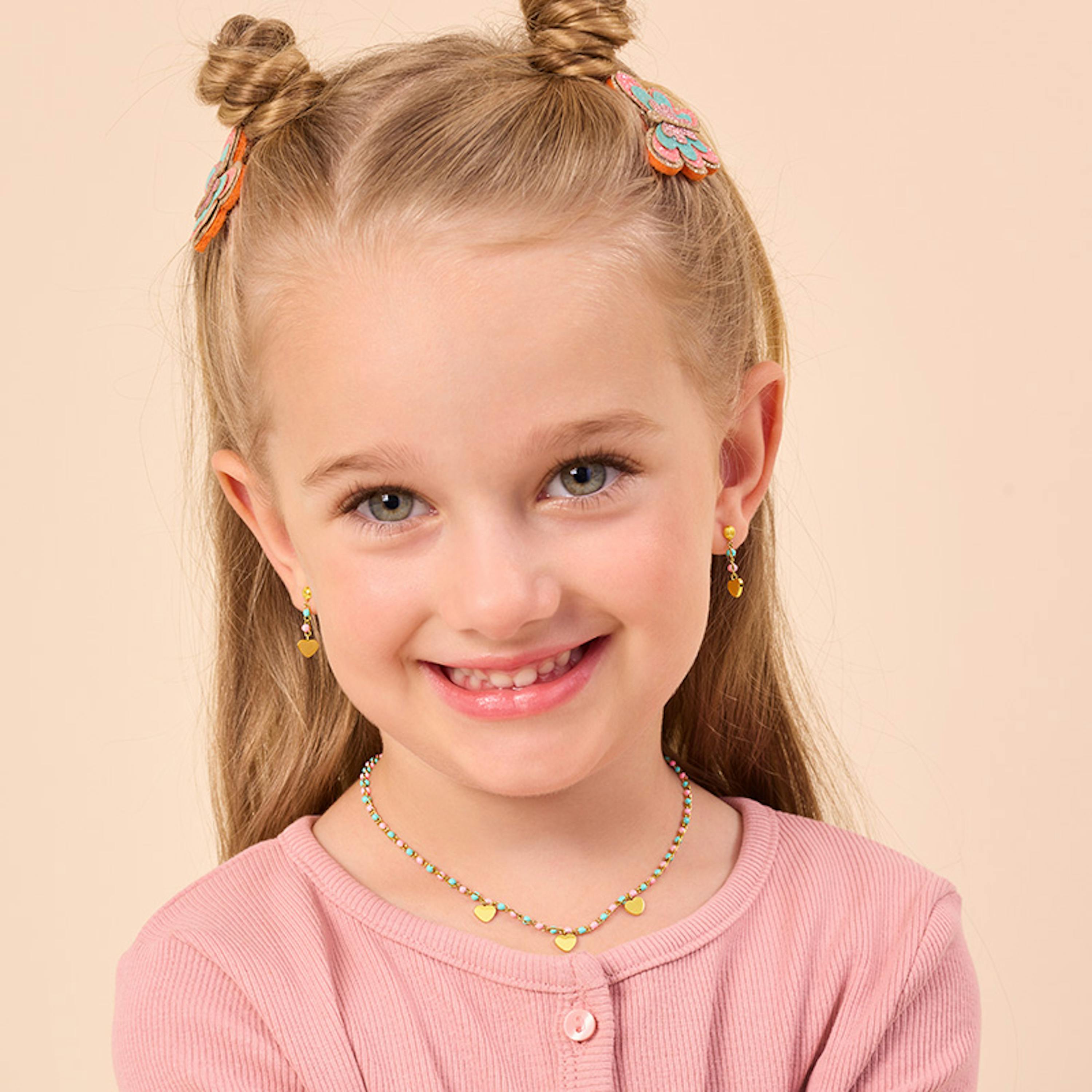 Mädchen trägt bunte Halskette und Ohrringe mit goldenen Herzchen von Prinzessin Lillifee