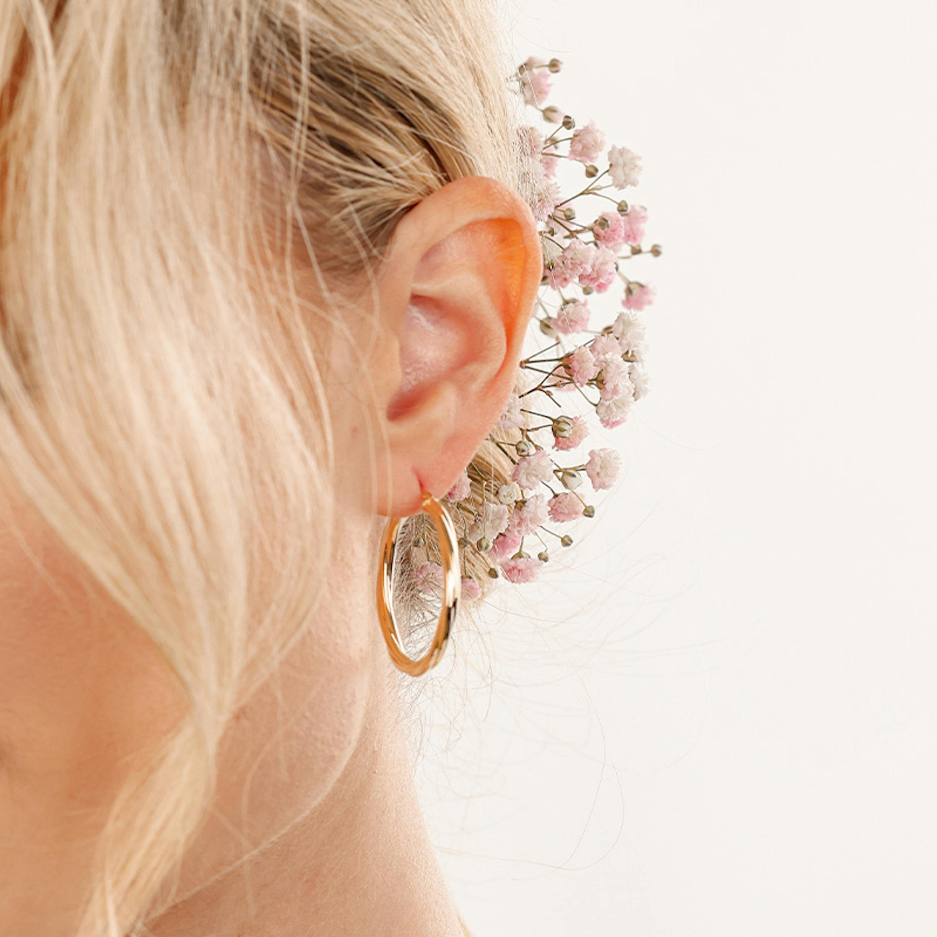 Braut trägt goldene Creolen von Amor zu passender Brautfrisur