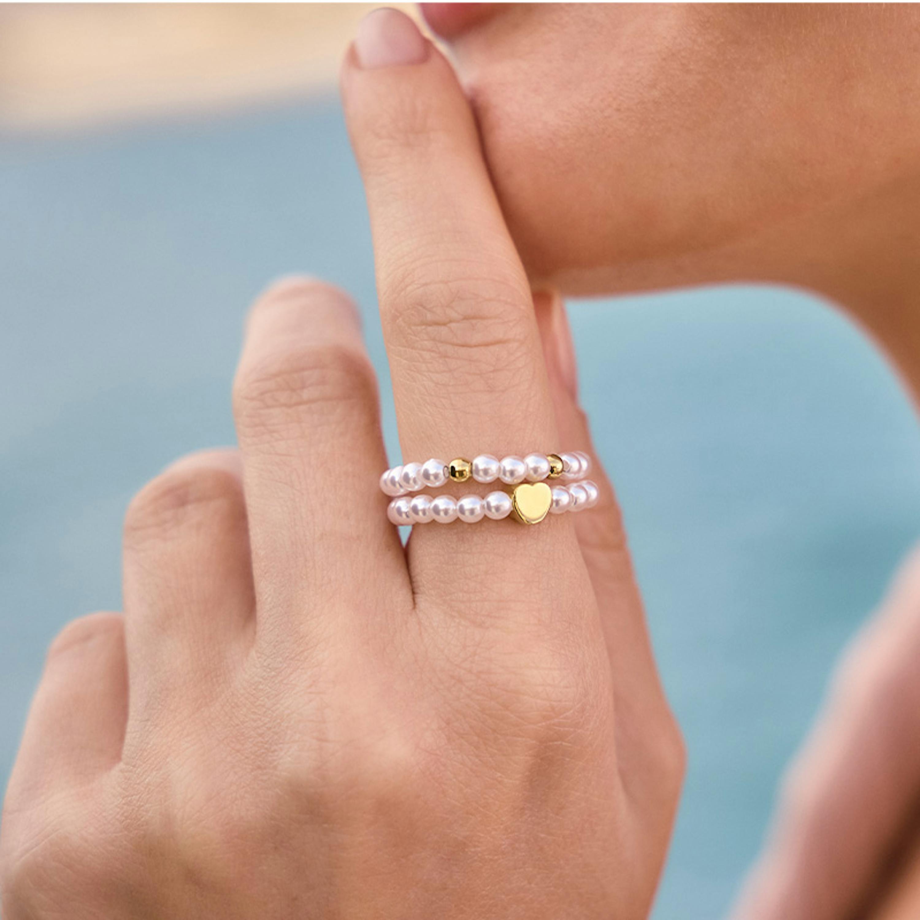 Frau trägt zwei Perlenringe der neuen Amor Summer Collection