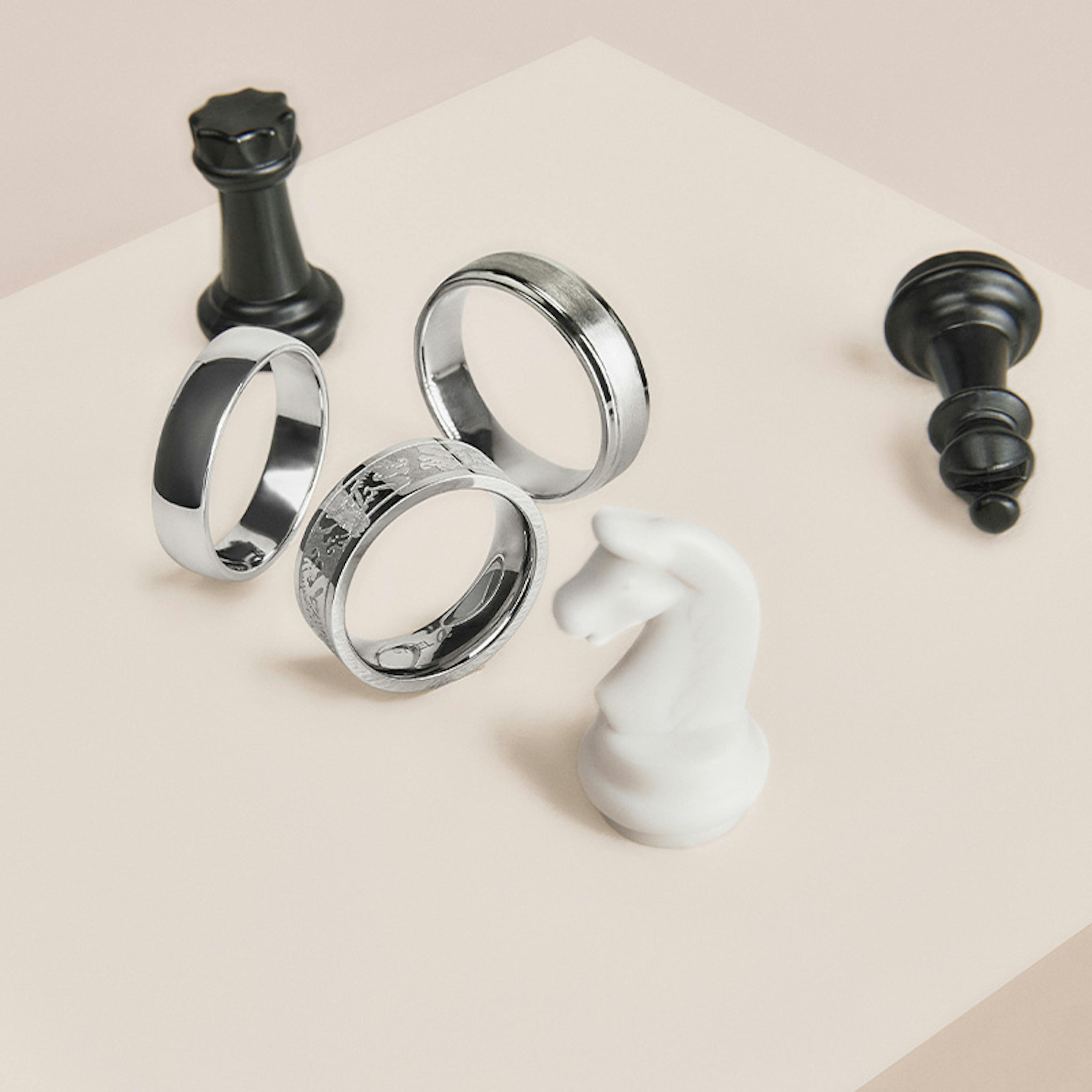 Edle Silberringe für Herren zwischen Schachfiguren platziert