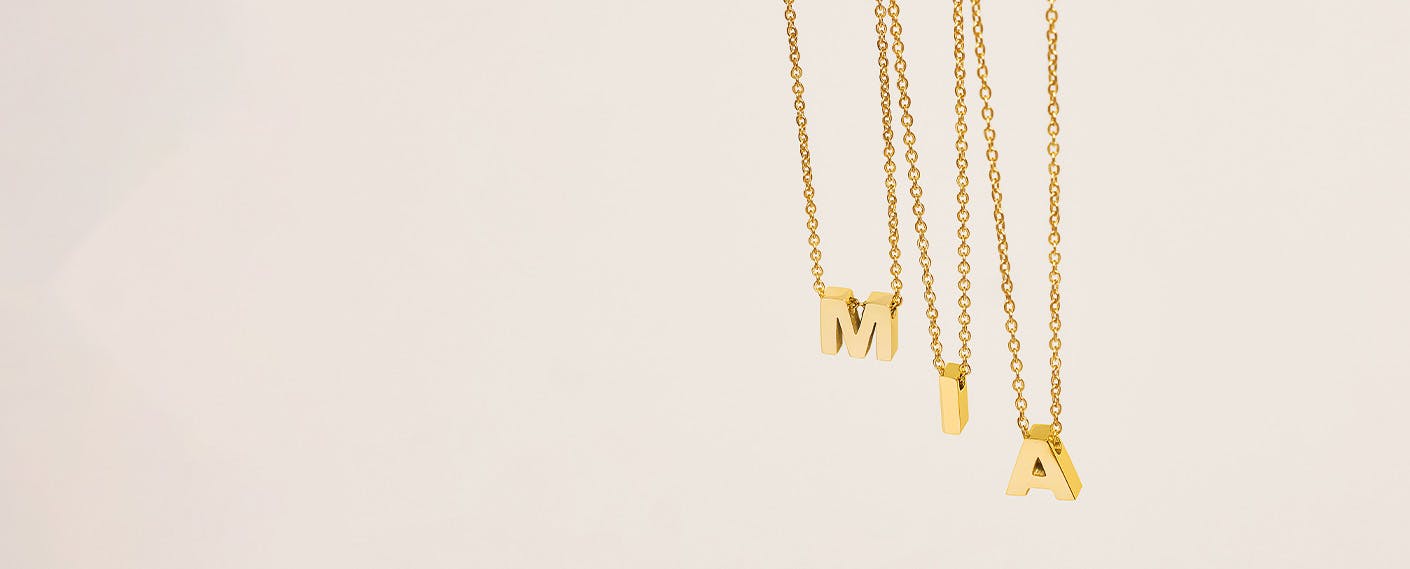 Goldene Buchstabenketten ergeben den Namen "MIA"